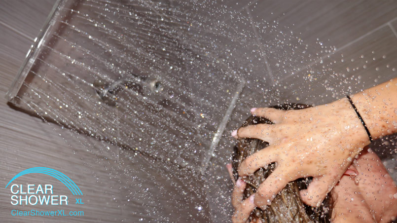 Girl using Clear showerhead in grey bathroom